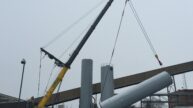 Large crane with pulley setting a silo in place