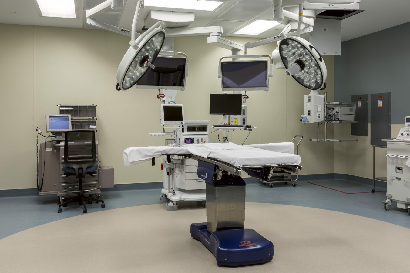 Empty operating table with surrounding medical equipment