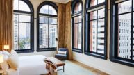 Historic commercial renovation project with a hotel bed surrounded by five large windows