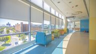 Elevator Bank Area of Children's Hospital. Along sun-filled windows are colorful lounge waiting chairs.