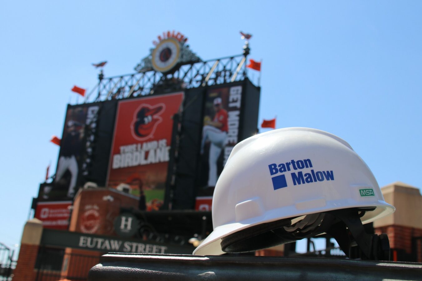 Barton Malow hardhat with Oriole Park in background