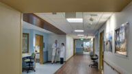 Doctors having discussion in hallway of patient rooms