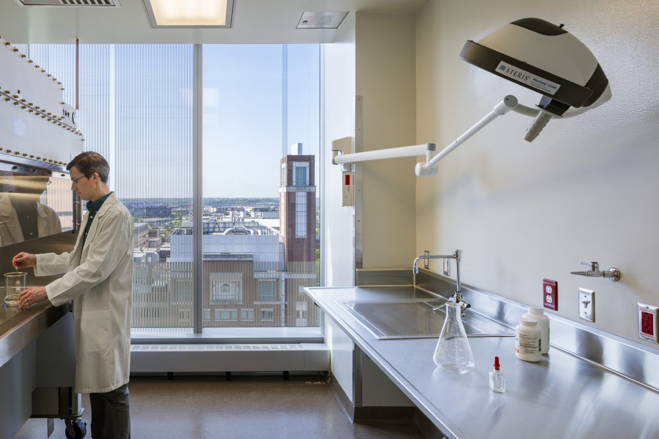 Person conducting research in a lab with a window overlooking Baltimore