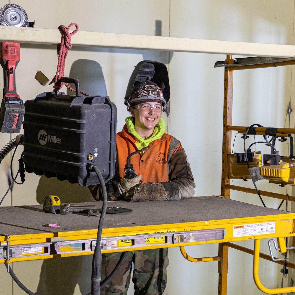 Female Ironworker Kyle Tripp smiling while getting ready to weld
