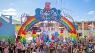 Guests celebrate the grand opening of Peppa Pig Theme Park infront of its colorful entrance