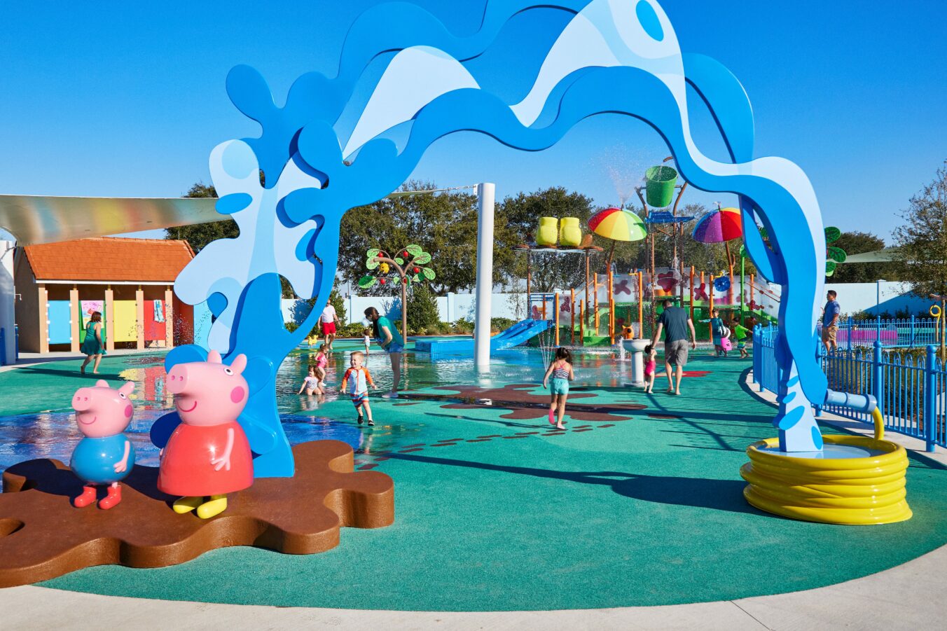 Kids splash at the colorful splash pad and water slides